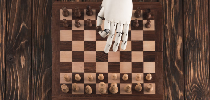 Robotic hand on chess board moving a piece
