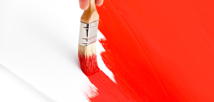Brush painting red paint.