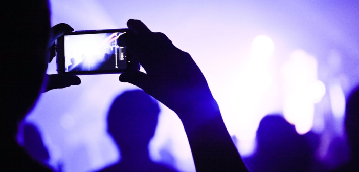 Someone talking a picture during a concert with a phone