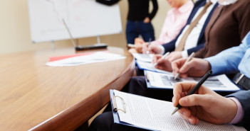 Close-up of businesspeople hands with documents writing at lecture