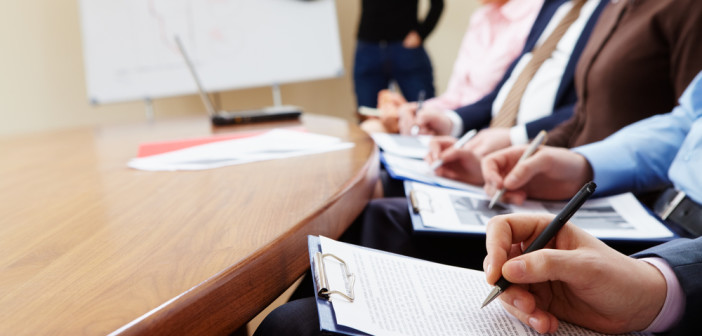 Close-up of businesspeople hands with documents writing at lecture