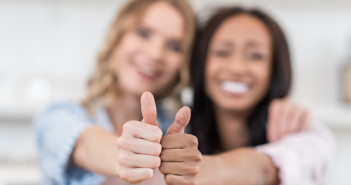 Two women giving a thumbs up