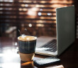 Coffee cup and laptop at home